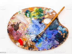Colourful artists oil paint palette and brushes close up on plain background
